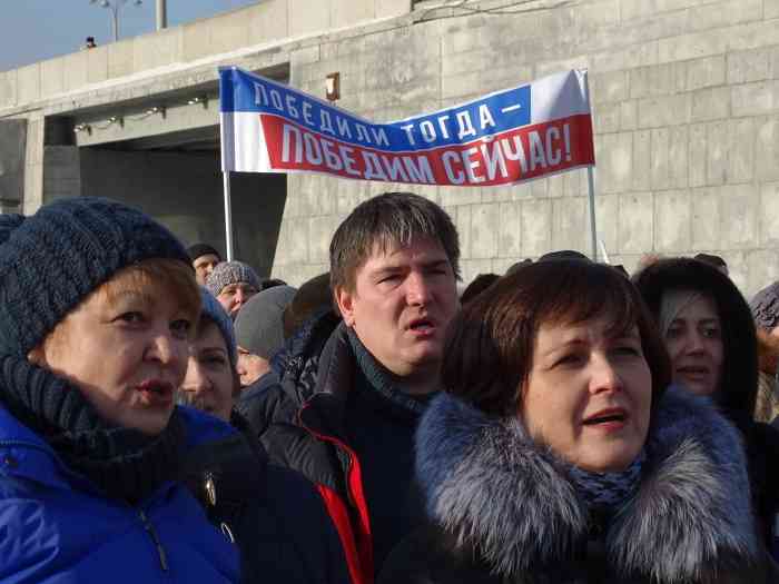 Участники митинга поют гимн России.