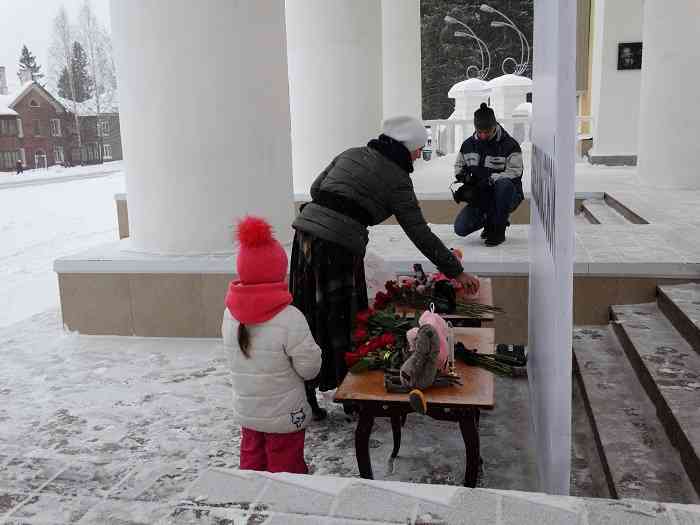 Горожане приходят с детьми. Оставляют цветы, игрушки, свечи.